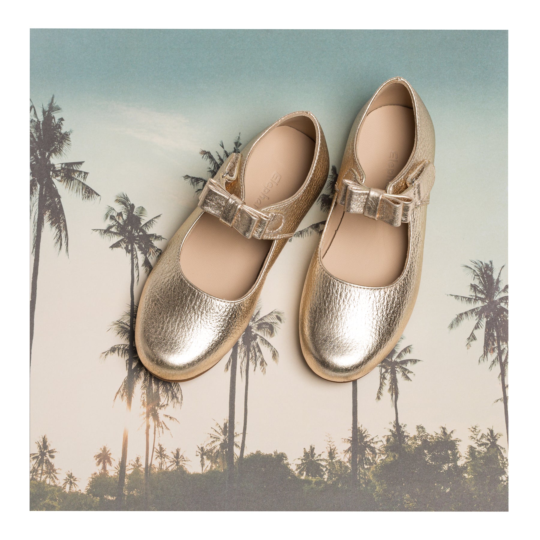 Gold metallic leather girls Mary Jane shoes with a buckle strap and rounded toe.