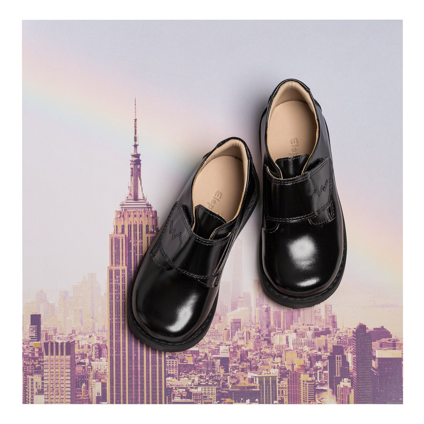 Black toddler dress shoes with glossy finish and rounded toes, slip-on design.