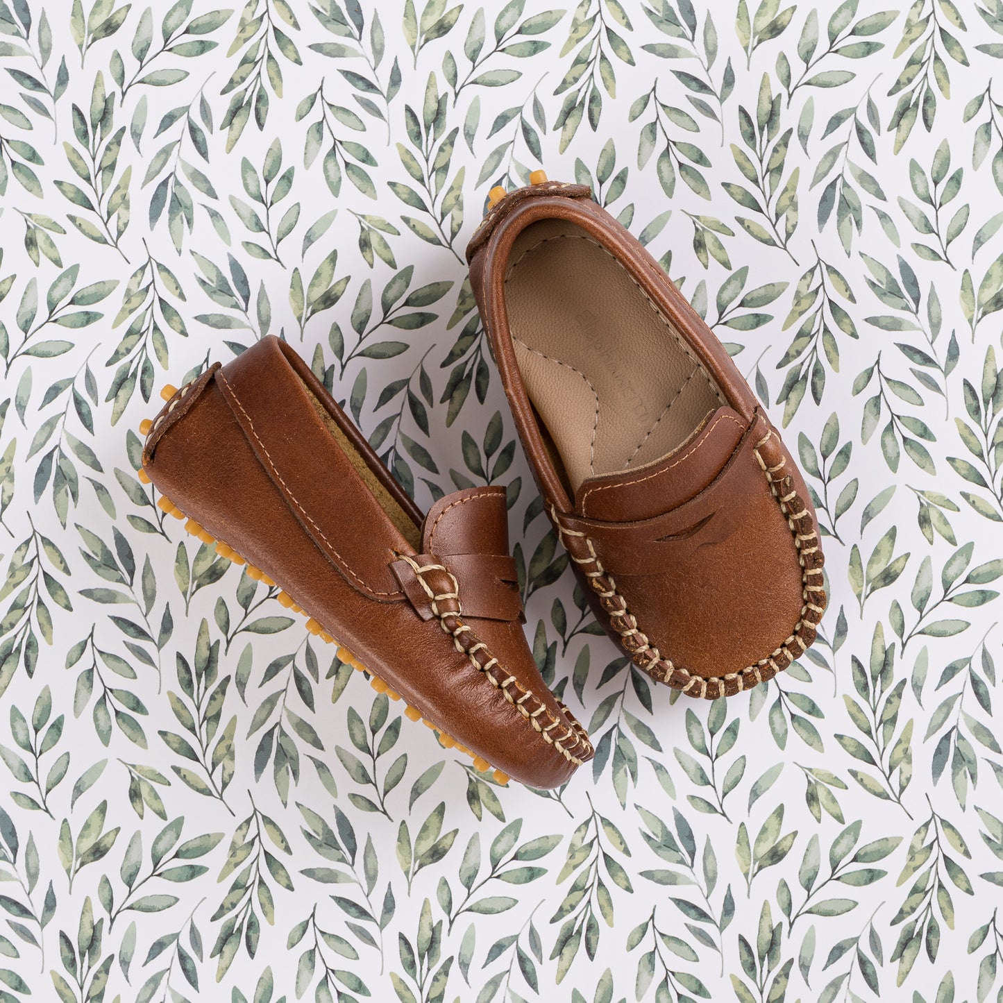 Natural brown toddler moccasin loafers with stitched detailing and buckle accent.