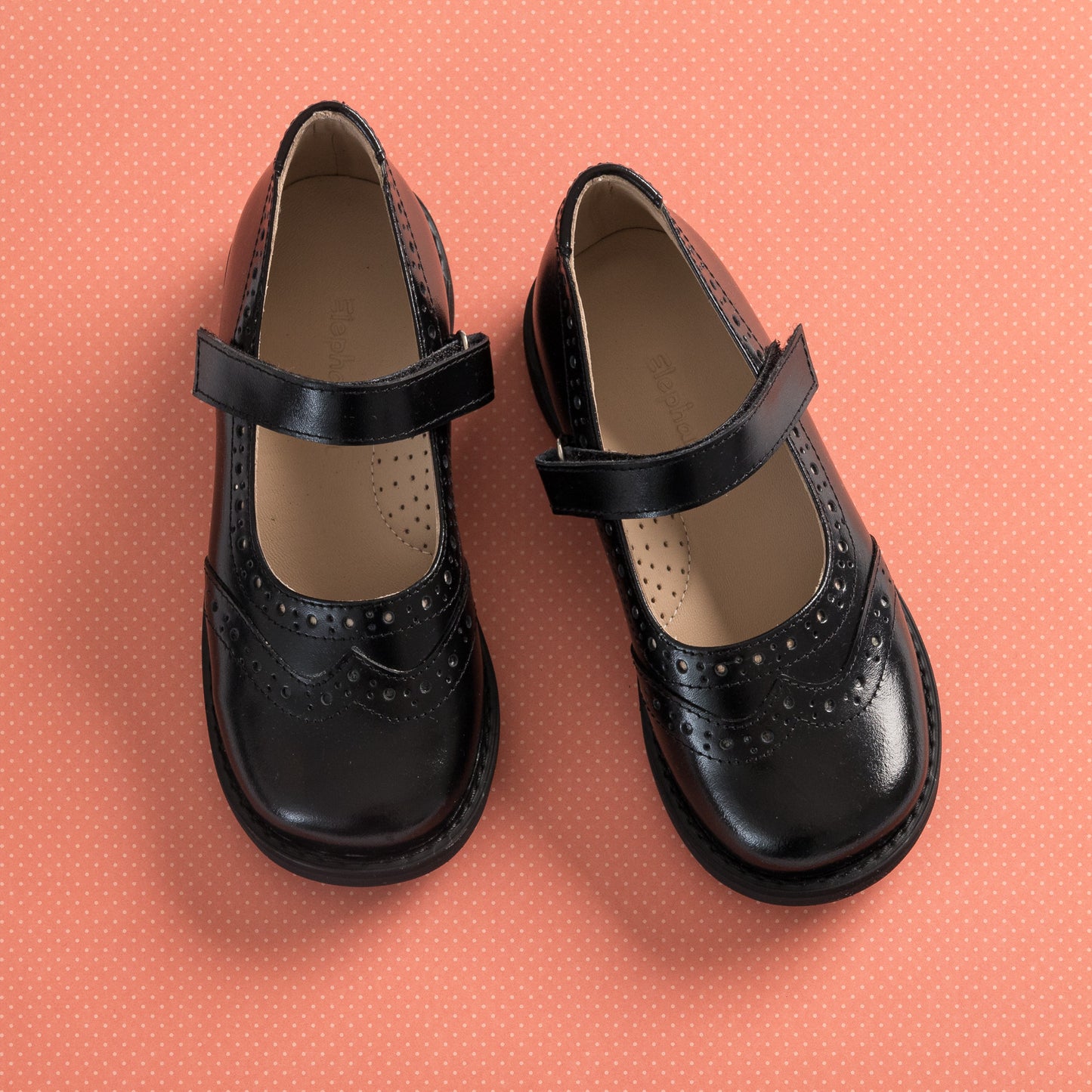 Black Mary Jane shoes for girls with perforated wingtip detailing and a single strap closure.