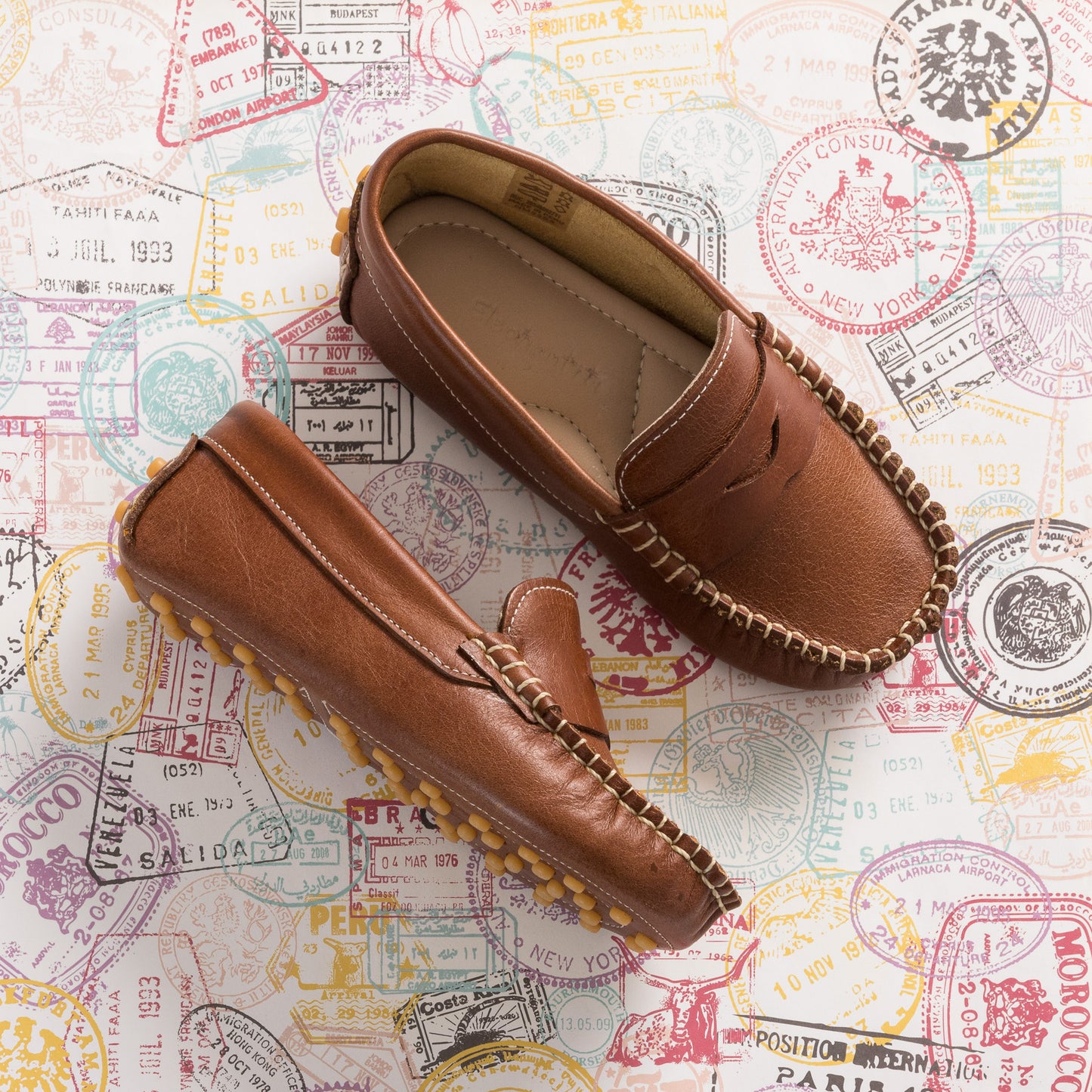 Natural brown boys loafers with stitched moccasin design and soft leather material.