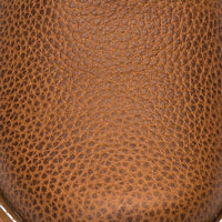 Brown pebbled leather texture of children's boot with a matte finish.
