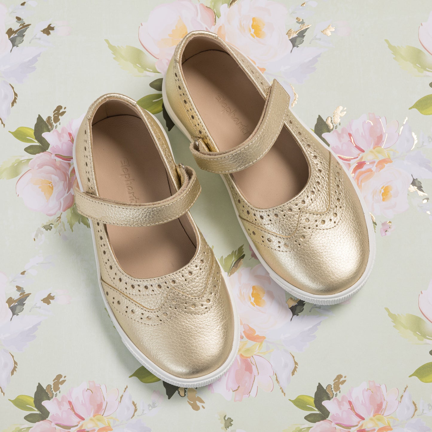 Gold metallic Mary Jane sneakers for girls with perforated detailing and white soles.