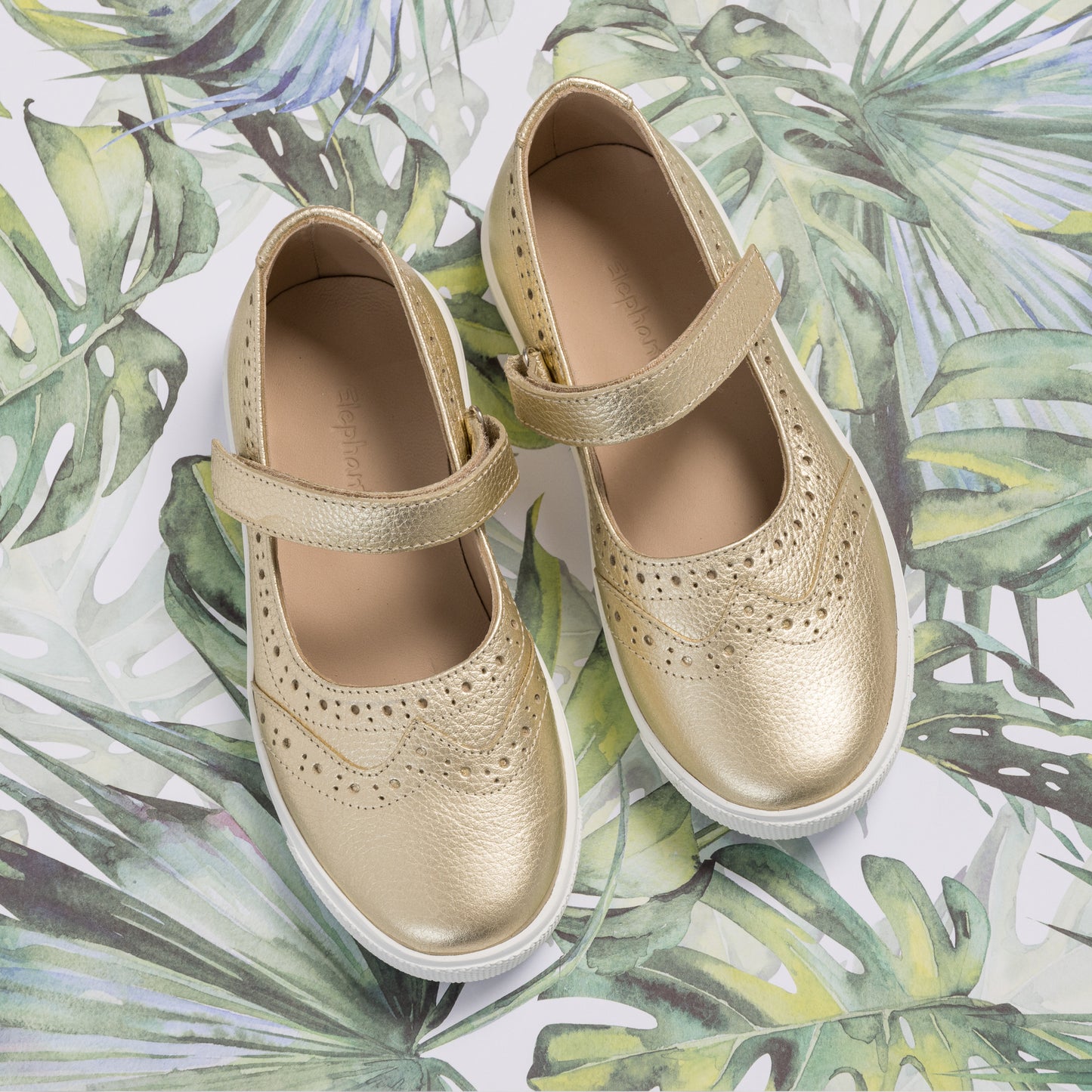 Gold metallic Mary Jane sneakers for toddlers with perforated wingtip detailing and Velcro straps.