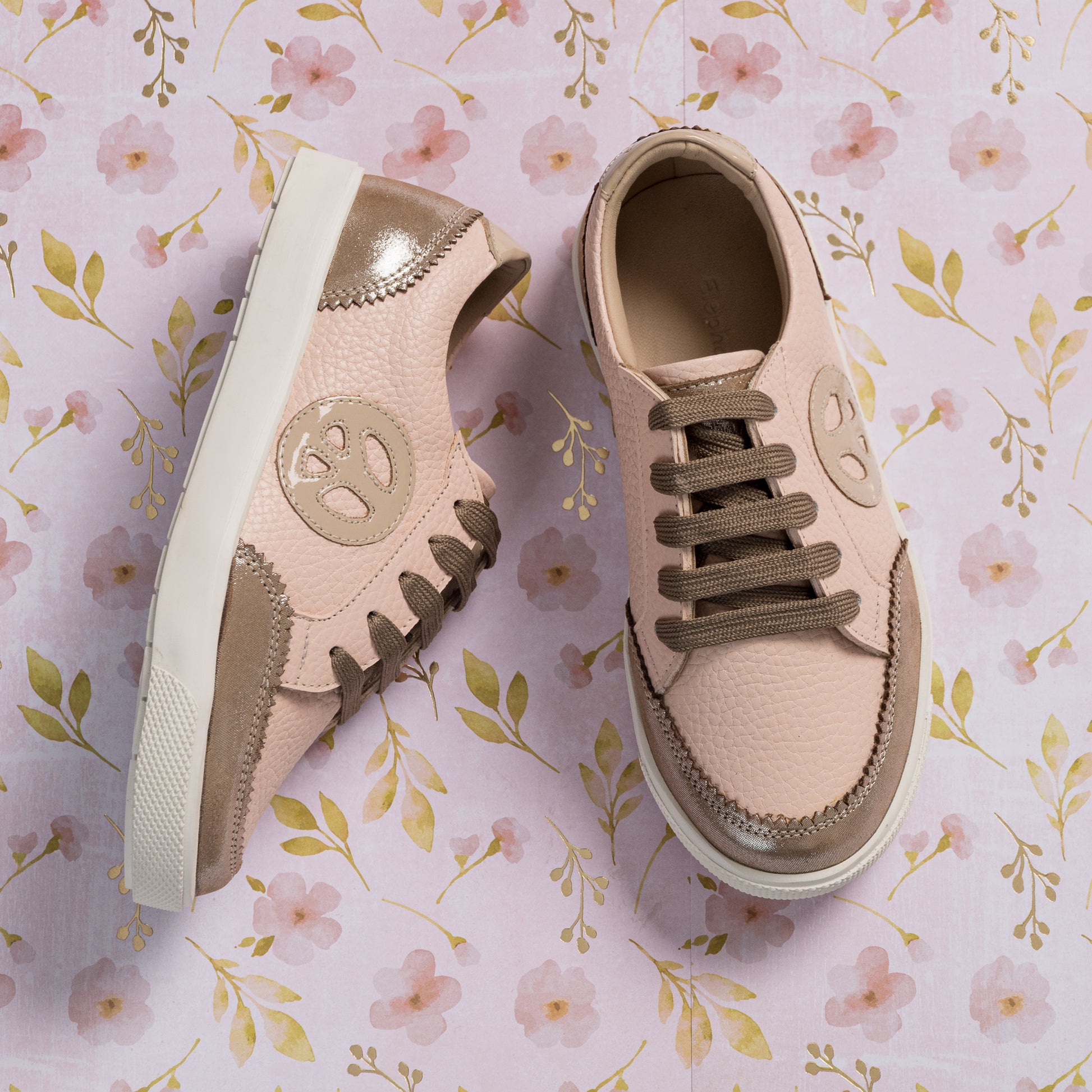 Textured pink and beige toddler sneakers with soft suede accents and round logo on side.