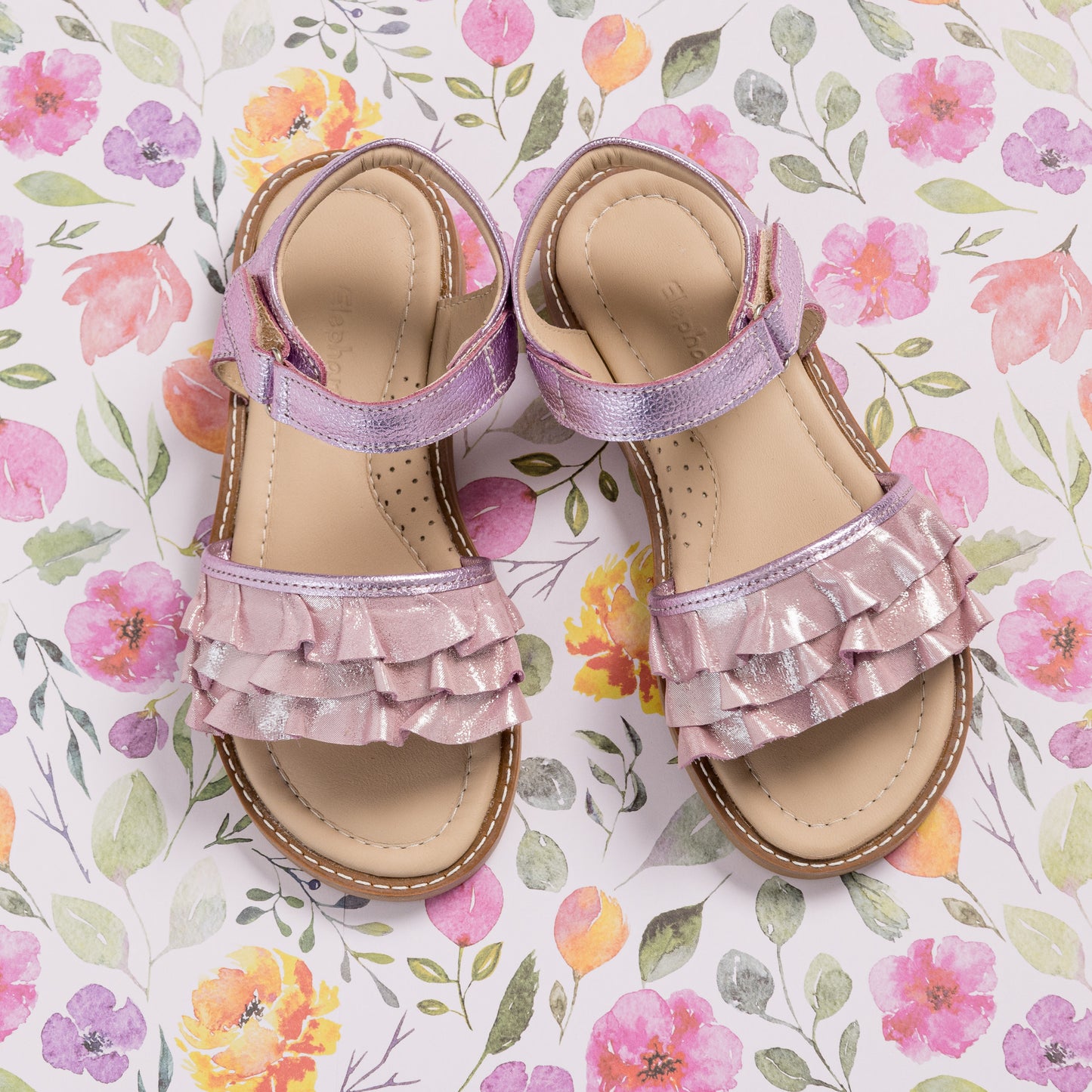 Toddler sandal in shiny carnation pink with ruffled straps and a velcro ankle closure.