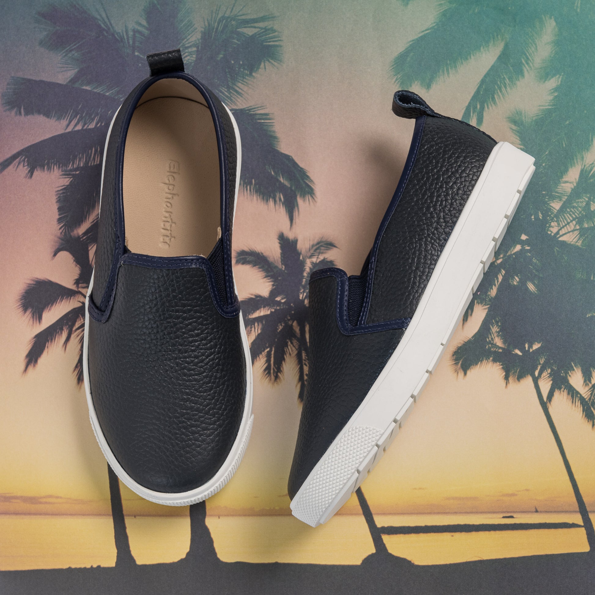 Textured navy blue slip-on toddler shoes with white soles and pull tabs at the heel.