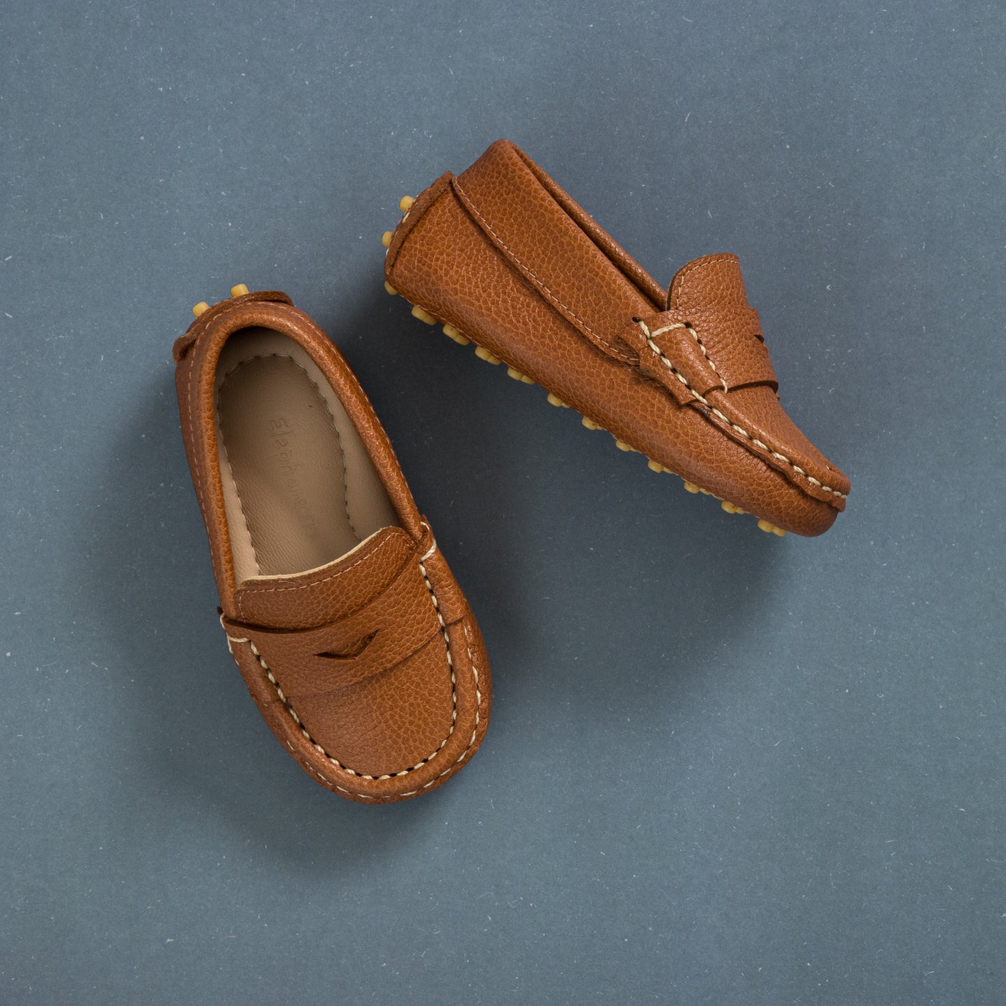 Tan toddler driver loafers with pebble-grain leather and moccasin stitching.
