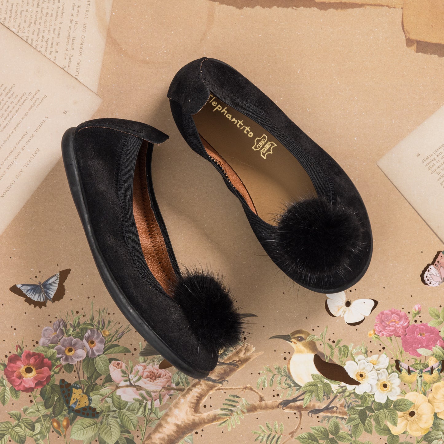 Black suede ballerina shoes for children with large black pom pom on toe.