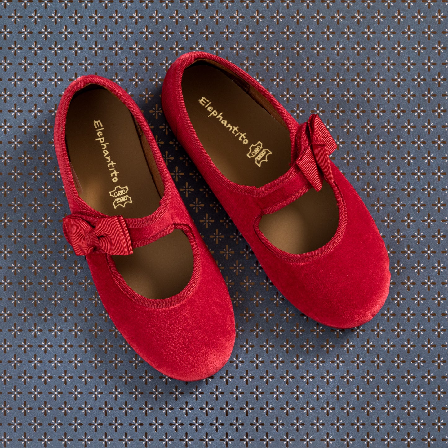 Red velvet Mary Jane shoes with bows on the straps for toddlers and kids.