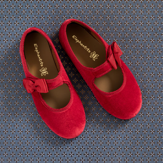 Red velvet Mary Jane shoes with bows on the straps for toddlers and kids.