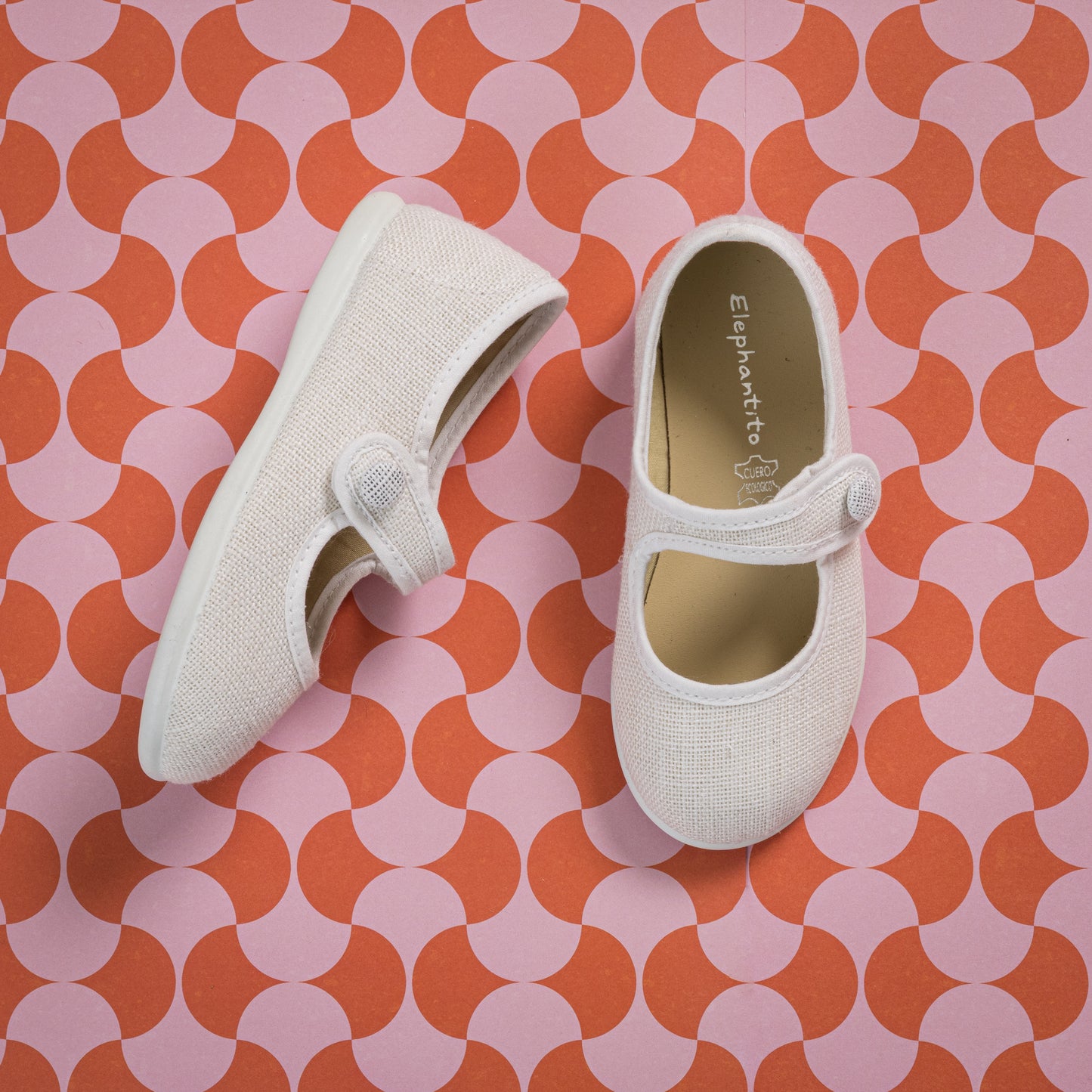White linen Mary Jane toddler shoes with adjustable hook-and-loop strap and rounded toe.