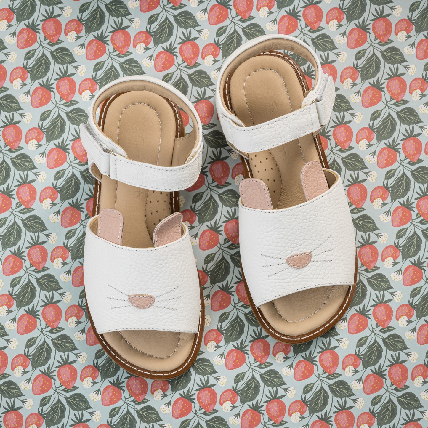 White toddler sandals with bunny face design, adjustable Velcro straps, cushioned insoles.