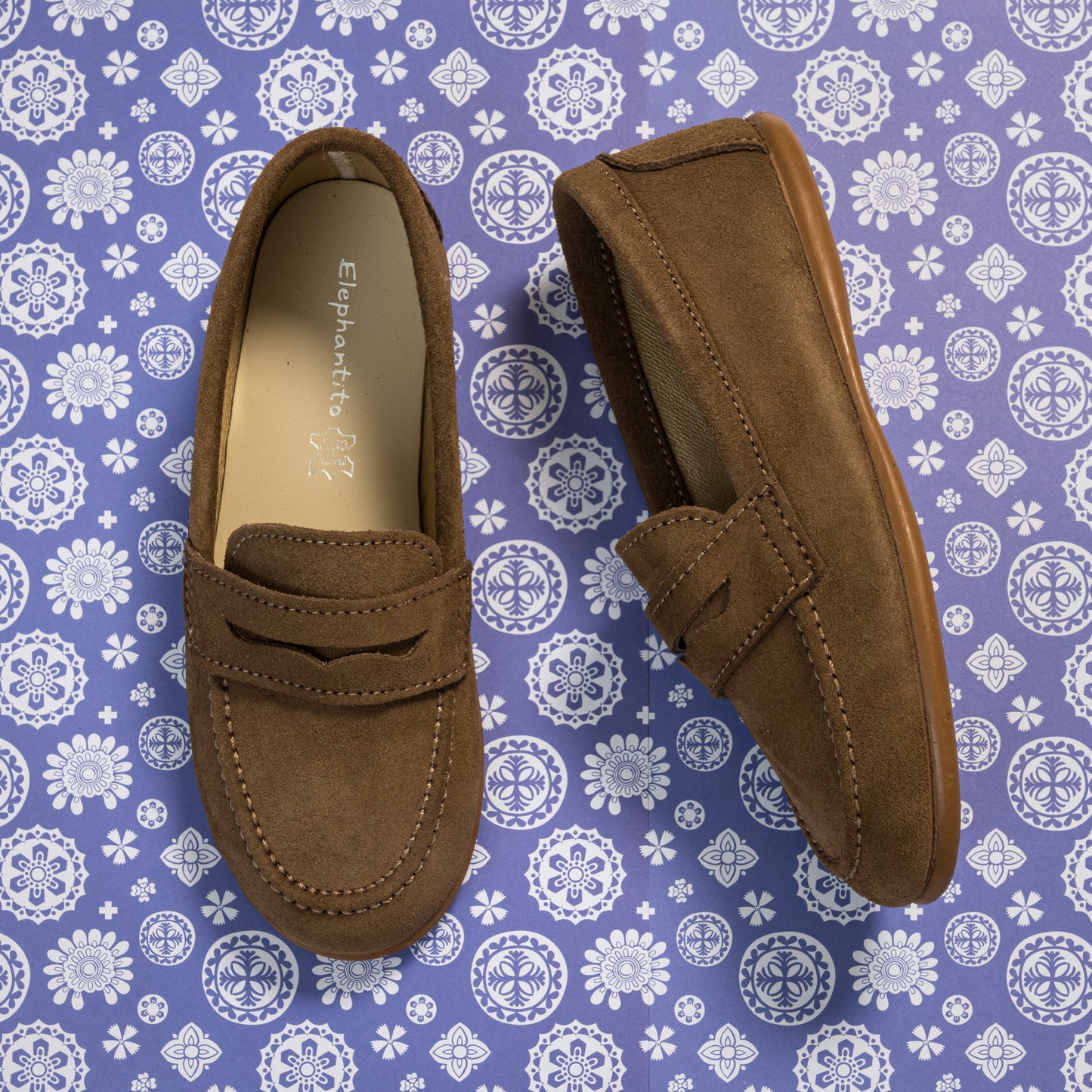 Toffee brown suede penny loafers for toddlers with stitched details and moccasin-style seams.
