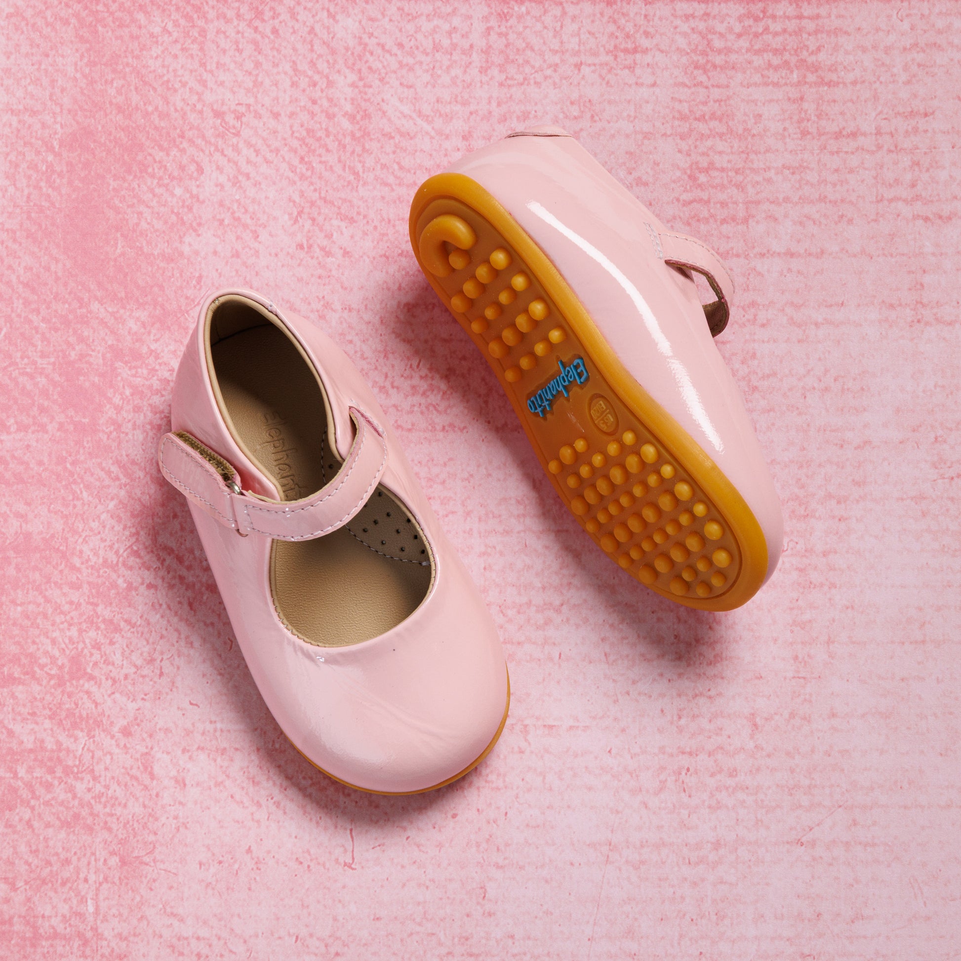 Pink patent leather toddler Mary Jane shoes with adjustable strap and rubber sole.