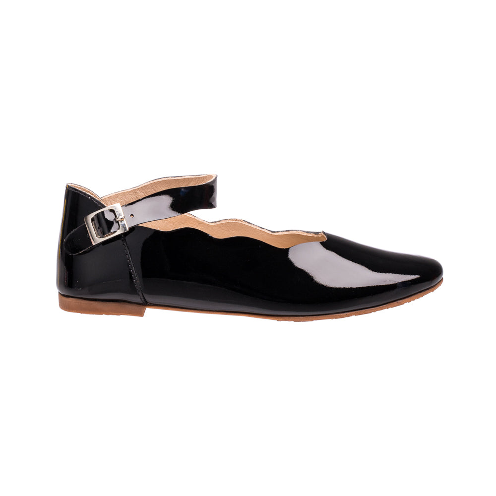Black patent leather children's flat with scalloped edge and ankle strap buckle.