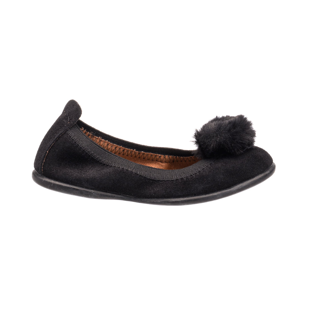 Black suede ballerina shoe with a fluffy pom pom on top and a rounded toe.