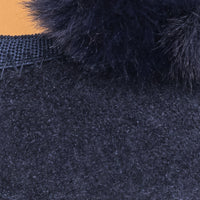 Close-up of navy blue suede ballerina shoe with matching fluffy pom pom detail and textured stitching.