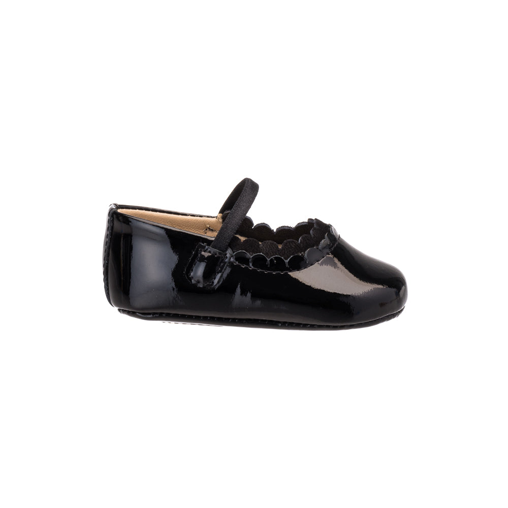 Glossy black patent leather baby ballet flat with scalloped edges and a strap across the top.