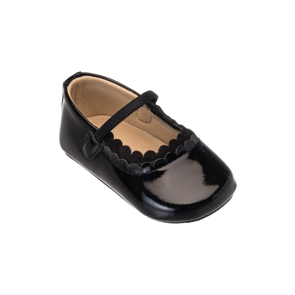 Black patent leather baby ballet flat with scalloped edge and single elastic strap.