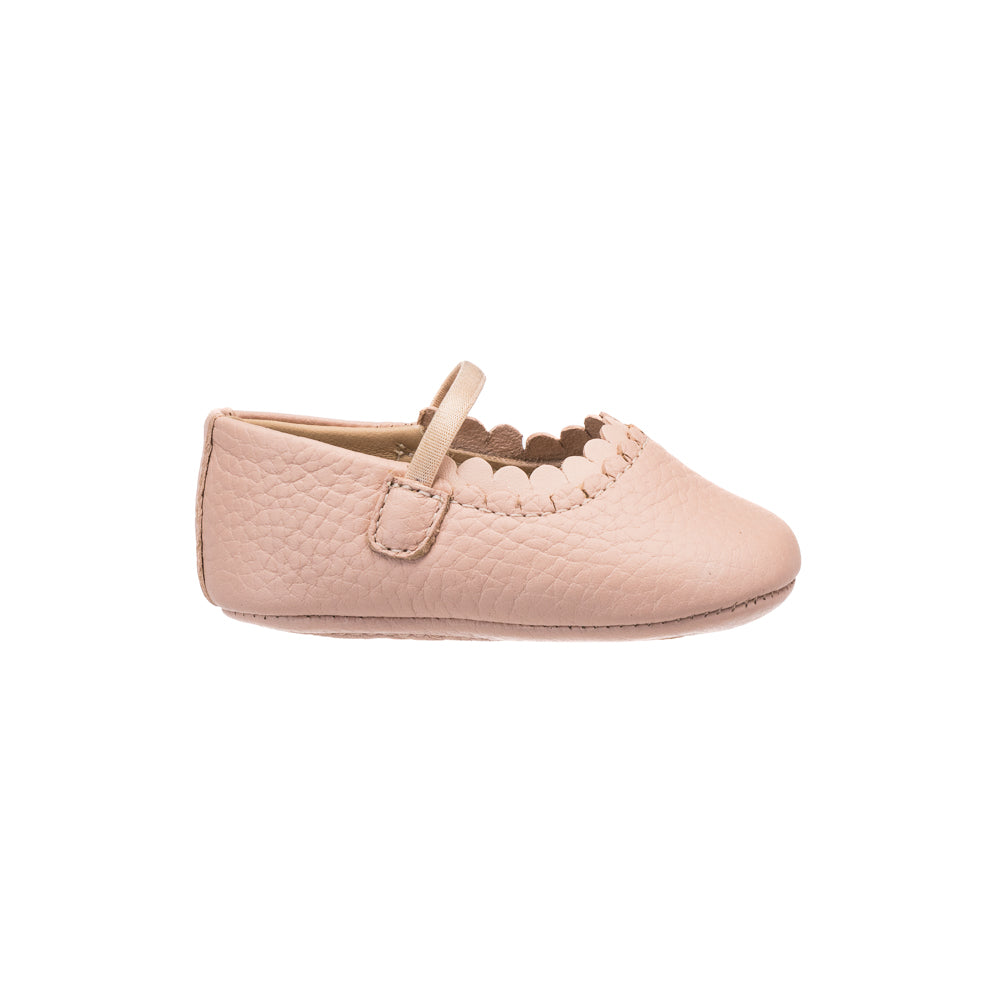 Soft pink baby shoe with scalloped edge and adjustable strap in textured leather.