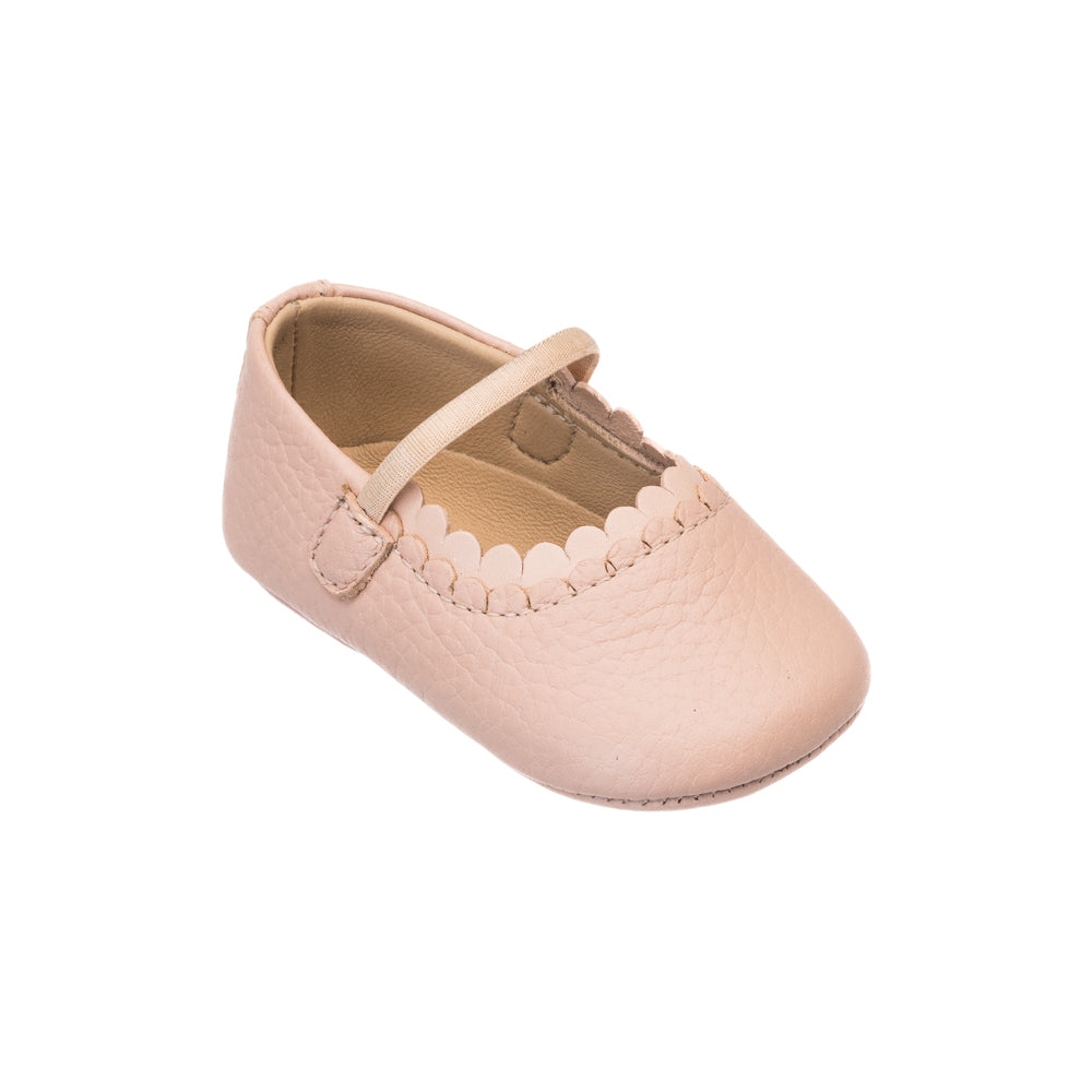 Baby pink faux leather Mary Jane shoe with scalloped trim and strap closure.