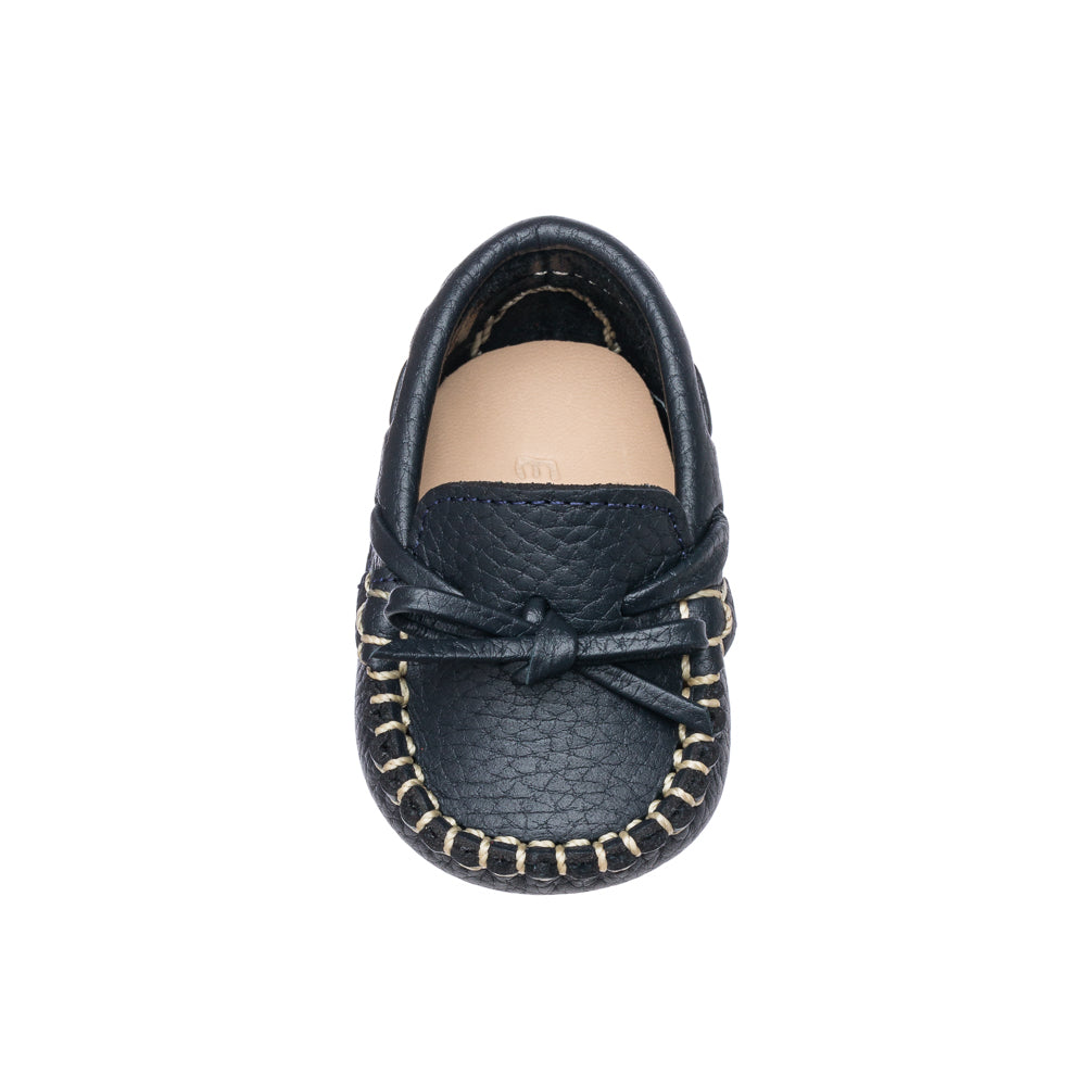 Navy blue baby loafer with textured leather, decorative bow, and contrast stitching.