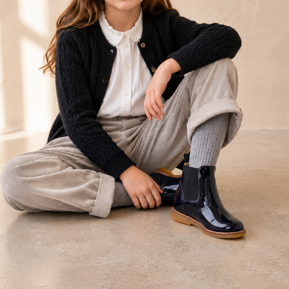 Elephantito - Black patent leather girls' ankle bootie with side zipper and tan sole.