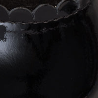 Glossy black patent leather baby ballet shoe with scalloped edge trim.