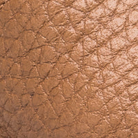 Close-up of caramel brown textured leather baby sandal material.