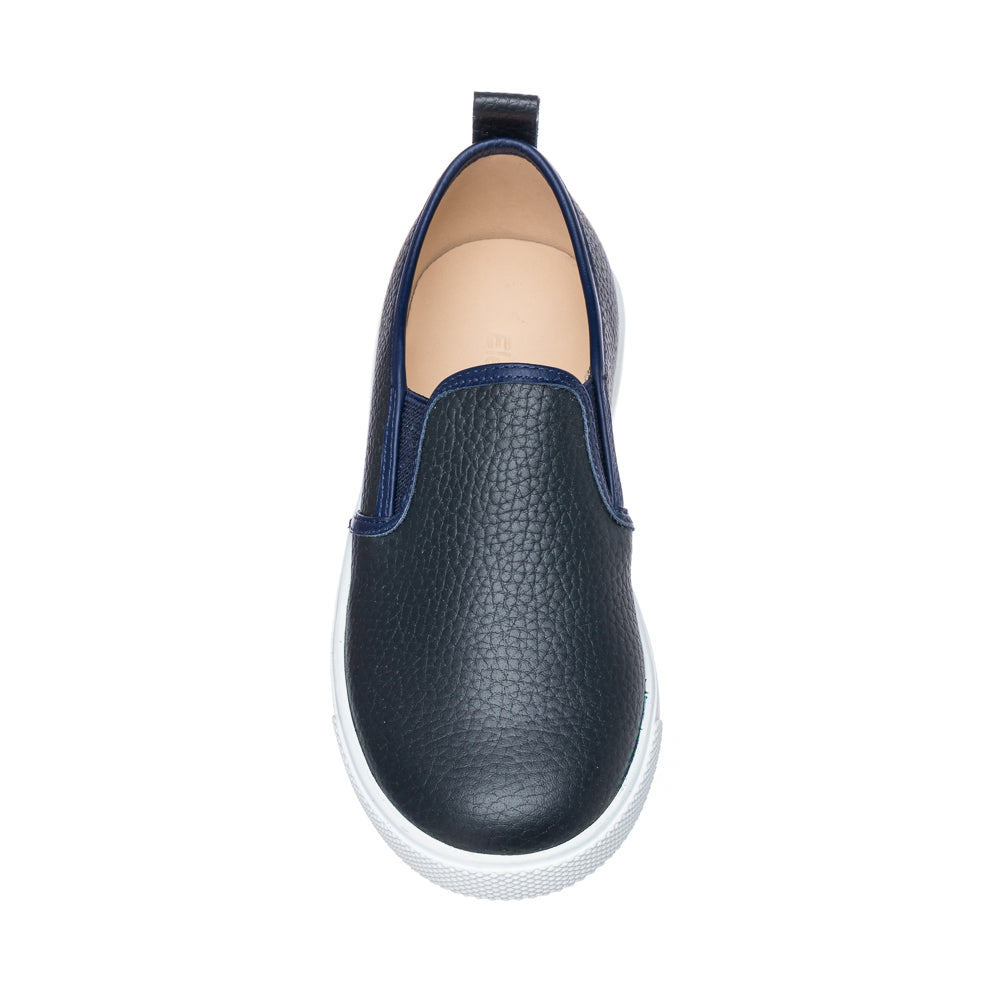 Textured navy blue slip-on shoe with white rubber sole and pull tab at heel for children.