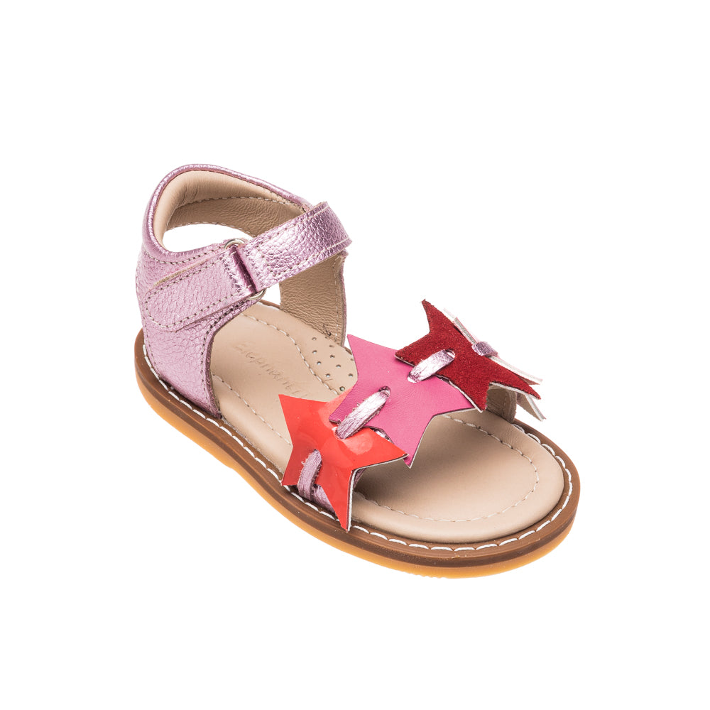 Toddler fuchsia sandal with star cutouts and metallic pink ankle strap on tan sole.