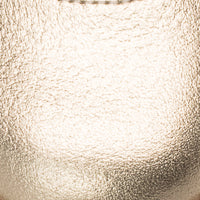 Close-up of textured metallic gold leather material on toddler Mary Jane shoe.