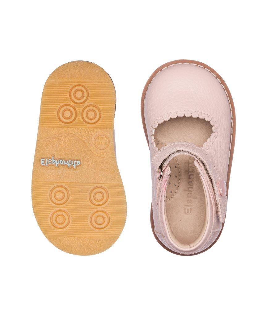 Pink leather toddler Mary Jane shoes with scalloped edges and rubber soles showing traction patterns.