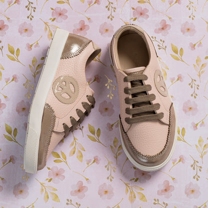 Textured pink and beige toddler sneakers with soft suede accents and round logo on side.