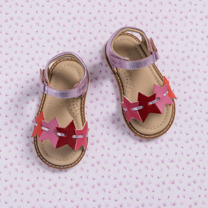 Toddler sandals in fuchsia and pink with star-shaped cutouts and adjustable ankle straps.
