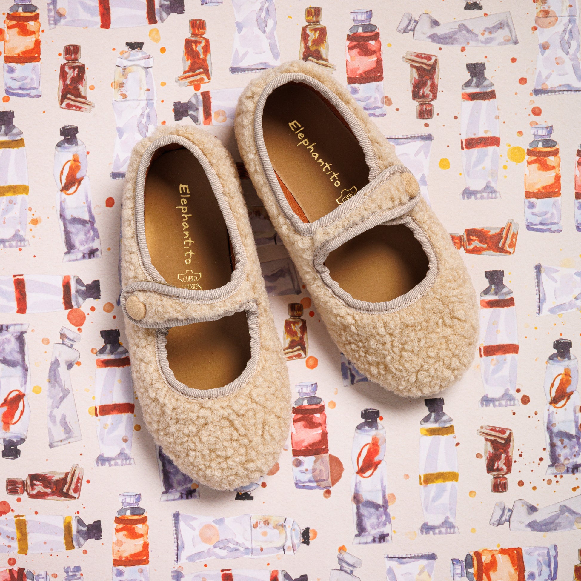 Beige shearling toddler Mary Jane shoes with rounded toes and strap closures.