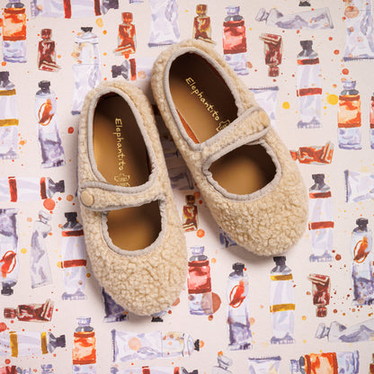 Beige shearling toddler Mary Jane shoes with rounded toes and strap closures.