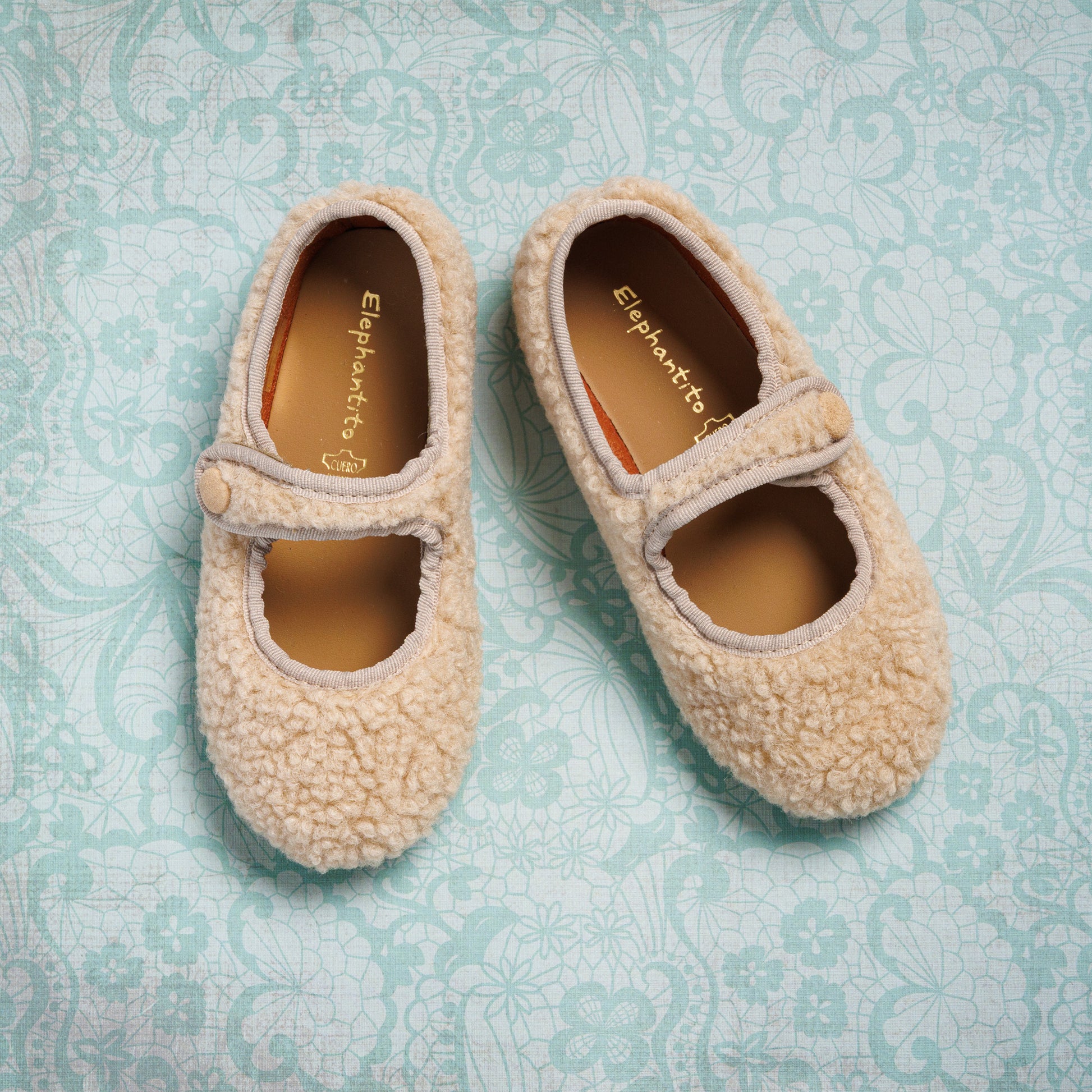 Beige shearling Mary Jane shoes for toddlers with a hook-and-loop strap and soft texture.