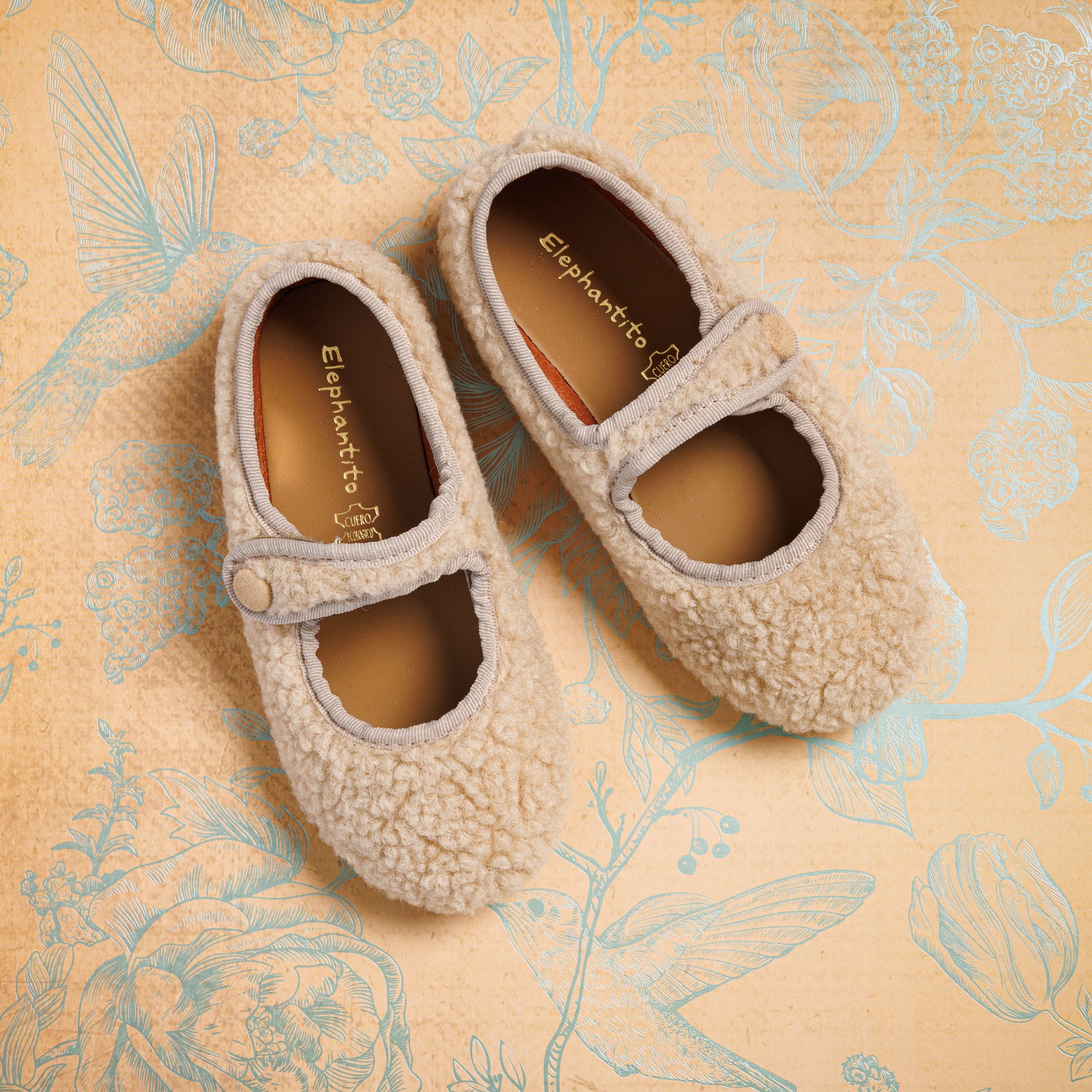 Beige shearling Mary Jane toddler shoes with rounded toes and hook-and-loop straps.