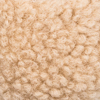 Close-up of soft beige shearling texture with curly wool fibers on kids' Mary Jane shoes.