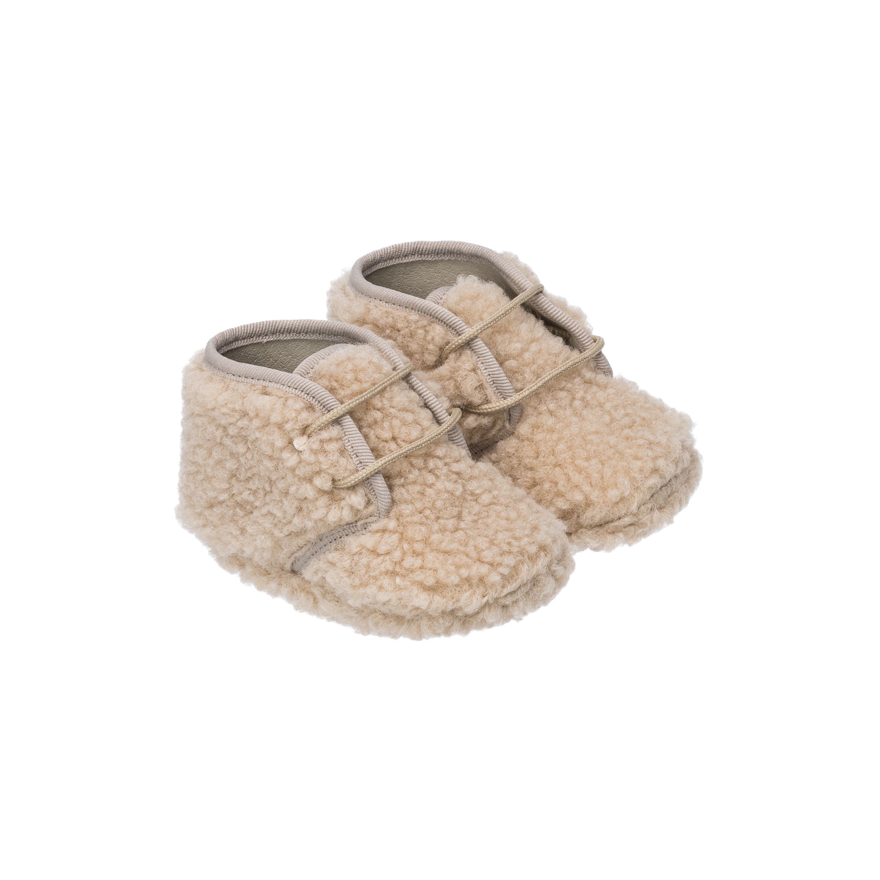 Beige shearling baby booties with soft textured exterior and adjustable strap closure.