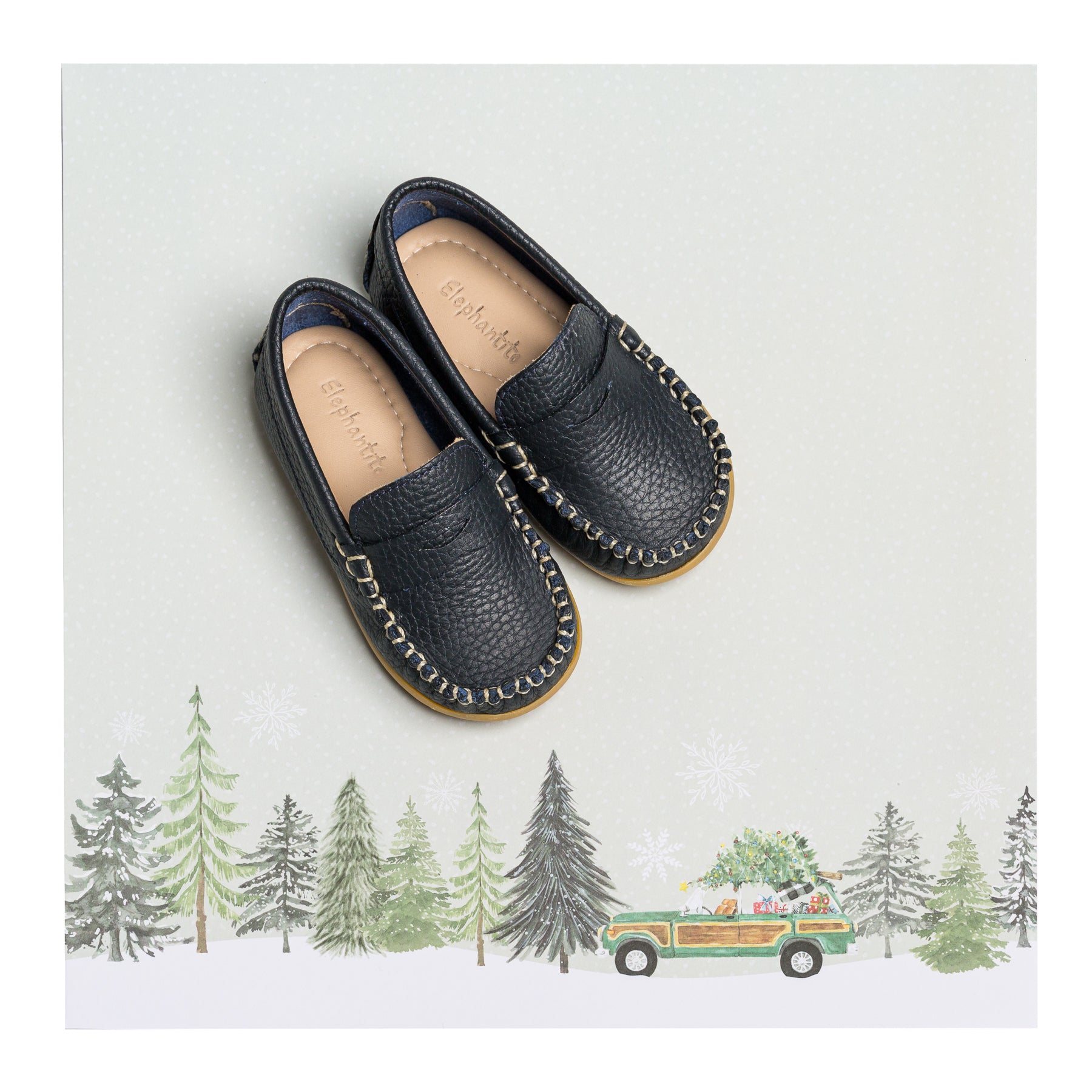 Navy blue boys loafers with textured leather and moccasin stitching on brown soles.