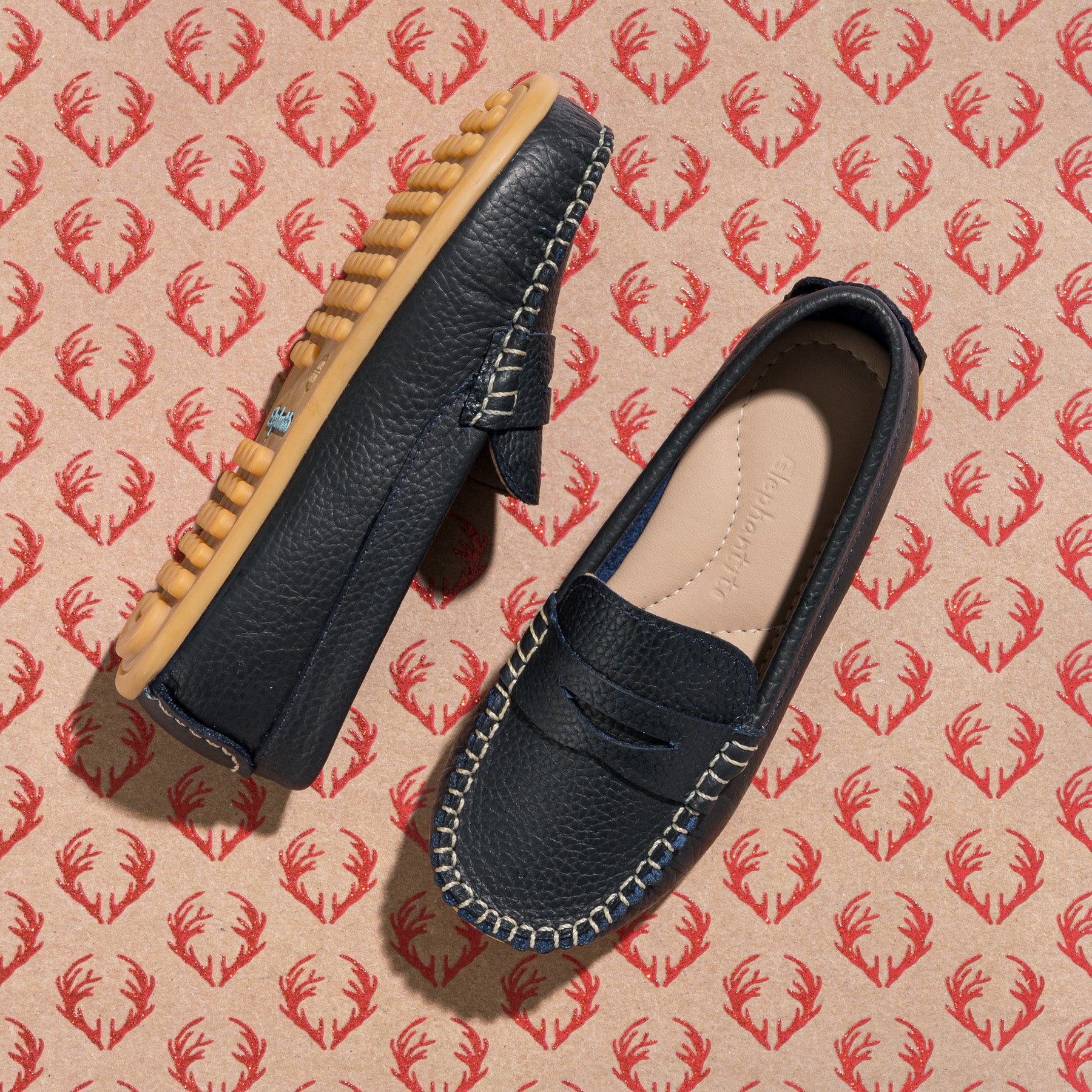 Navy blue toddler loafers with tan rubber sole and contrasting white stitching.