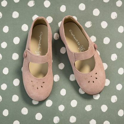 Pink suede Mary Jane shoes with perforated floral details and Velcro strap for toddlers.
