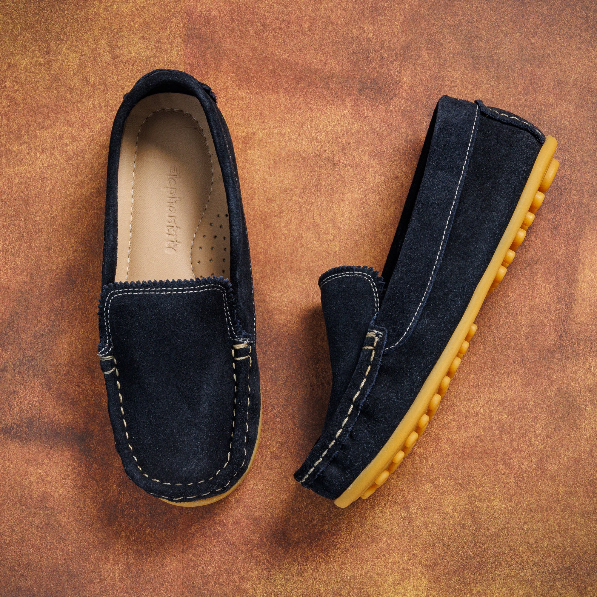Navy blue suede toddler moccasin driving shoes with tan rubber soles and contrast stitching.