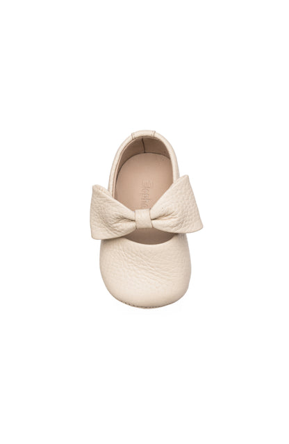 Cream baby ballerina shoe with textured large bow and soft rounded toe.