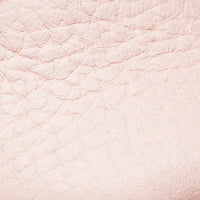 Soft pink textured leather close-up showing fine grain and subtle wrinkles.