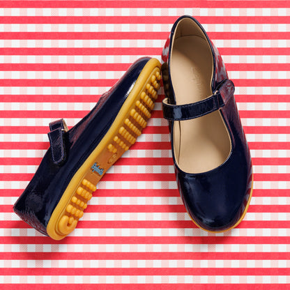 Glossy navy blue Mary Jane shoes for kids with yellow rubber soles and adjustable strap.