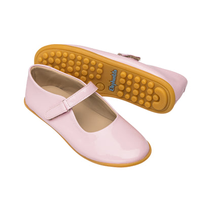 Glossy light pink Mary Jane shoes with a smooth finish and yellow rubber soles for toddlers.